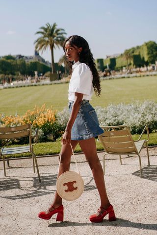 a photo of a woman's outfit with red mary jane shoes and a denim mini skirt and white shirt
