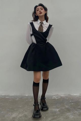 a photo of a woman's outfit with mary jane shoes and knee-high socks and a flare dress over a button-down shirt