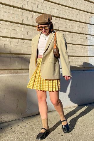 a photo of a woman's outfit with mary jane shoes with a plaid mini skirt and t-shirt and blazer