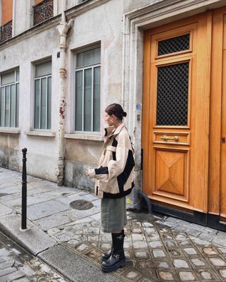 Alyssa wears engineer boots, bermuda shorts, and a black and white jacket.