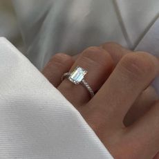 close up of fashion influencer Rikke Krefting Ulstein's emerald cut diamond engagement ring with a pave band