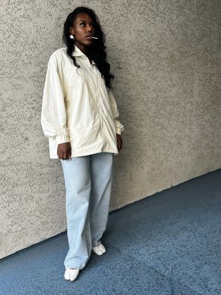 a photo of a woman wearing baggy denim jeans with a white shirt and white Tabi shoes