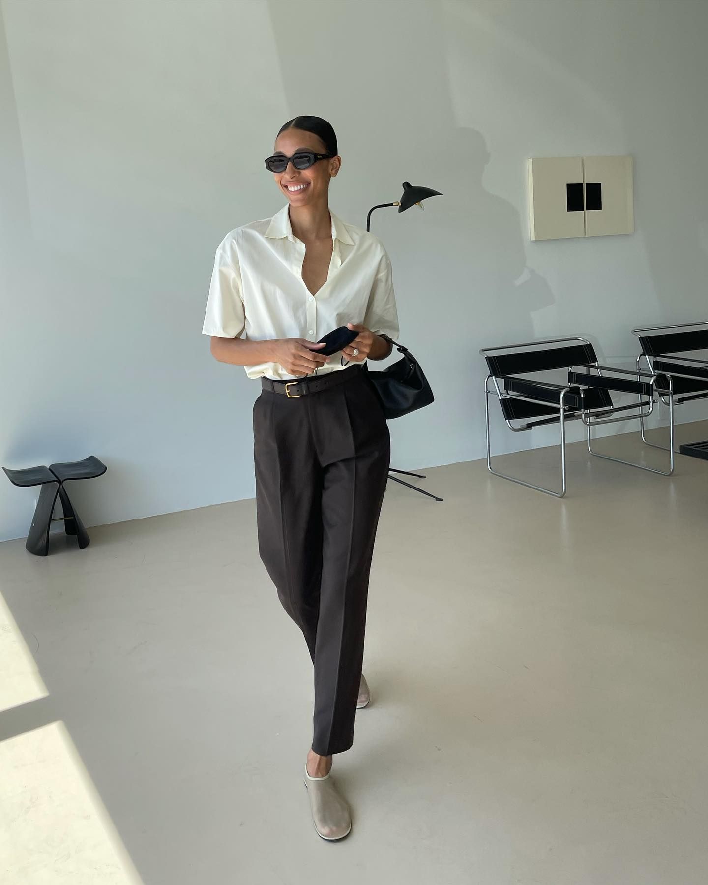 Influencer TyLynn Guyen wears The Row sock shoe in beige, a brown suit trouser, and off-yellow shirt and brown belt.