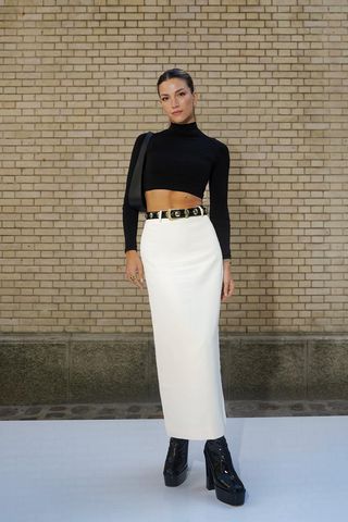 a woman's skirt outfit with a white column maxi styled with a cropped black turtleneck and black platform boots