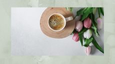 Mug of coffee next to a fresh bouquet of flowers