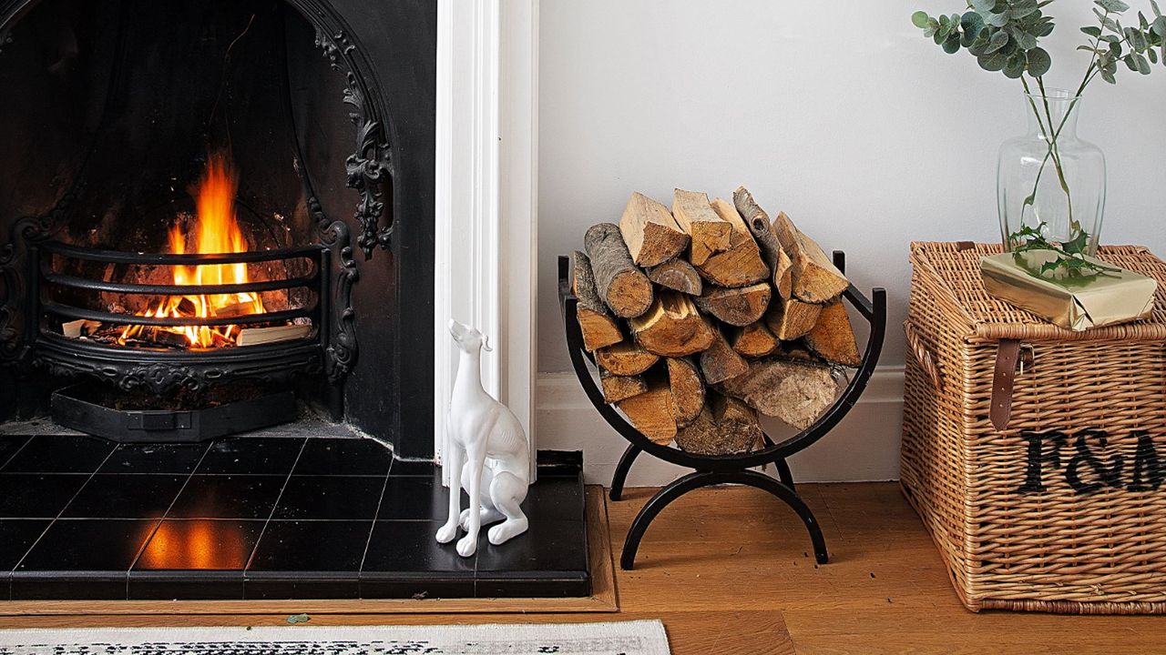 Living room detail of white wall mirror over Edwardian lit fireplace with Christmas decorations