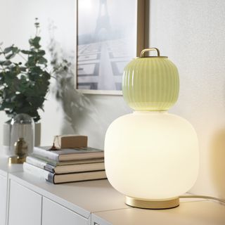 A side table with an art deco style table lamp with frosted glass