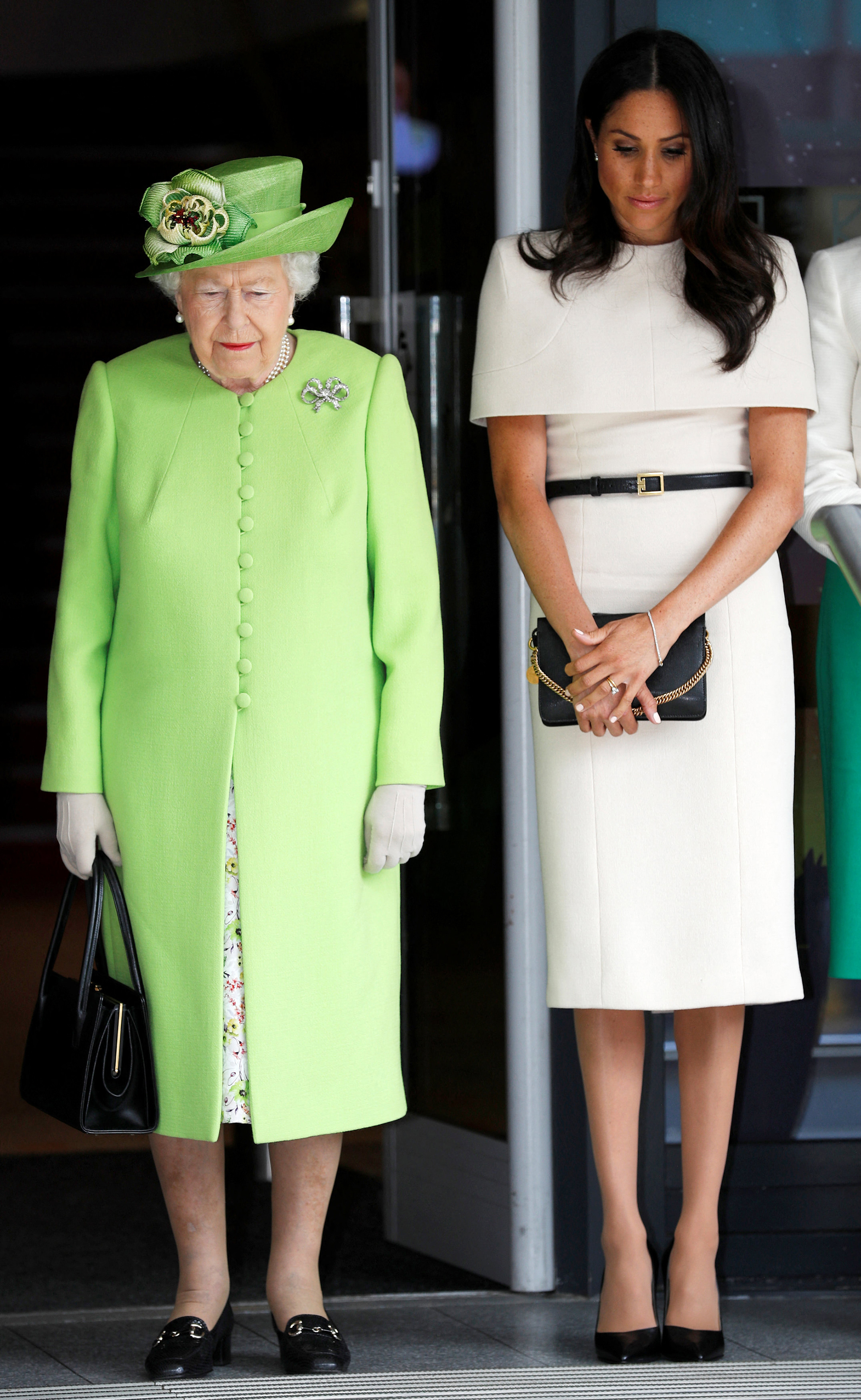 Britain's Queen Elizabeth II and Meghan, Duchess of Sussex observe a moment of silence in memory of the victims of the Grenfell Tower fire during their visit to Chester, Cheshire on June 14, 2018. (Photo by PHIL NOBLE / POOL / AFP) (Photo by PHIL NOBLE/POOL/AFP via Getty Images)
