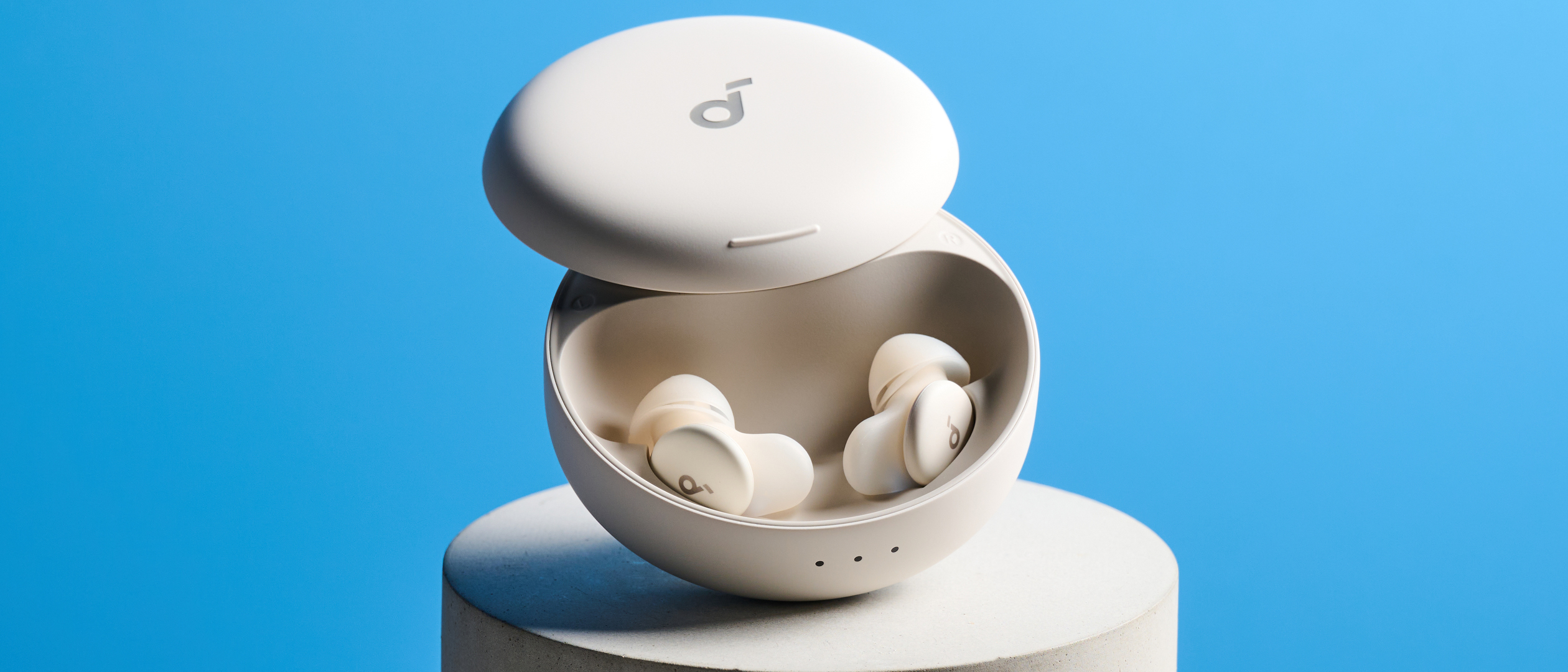 The Soundcore Sleep A30 earbuds in their case on a stone plinth against a blue background