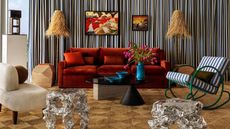 a living room with a red couch, green chair and sculptural side tables