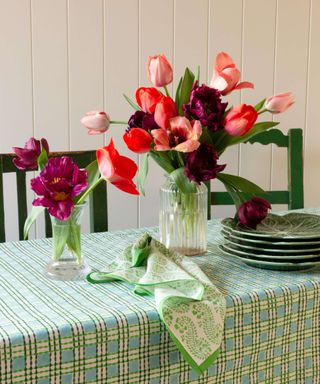 Molly Mahon green trellis design tablecloth with vase and pink flowers