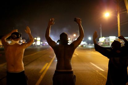 Demonstrators raise their hands to protest the shooting death of Michael Brown in Ferguson, Missouri