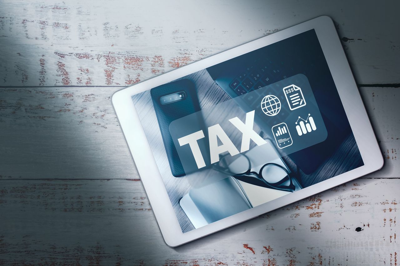 image of a tablet with the word tax and icons on it