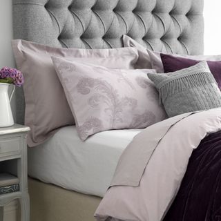 bedroom with white wall and pillows on bed