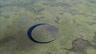 Aerial view of El Ojo in Argentina. The island is perfectly round, flat and covered in cropped vegetation.