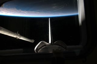 Atlantis and its Orbiter Boom Sensor System float above the Earth