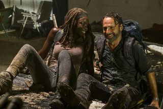 rick and michonne laughing on the ground in a still from The Walking Dead