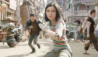 Alita: Battle Angel Alita takes a fighting stance with Hugo rushing to stop her