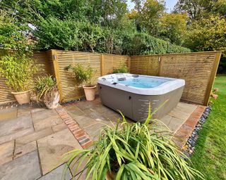 hot tub from hydrolife with slatted wooden fence screen