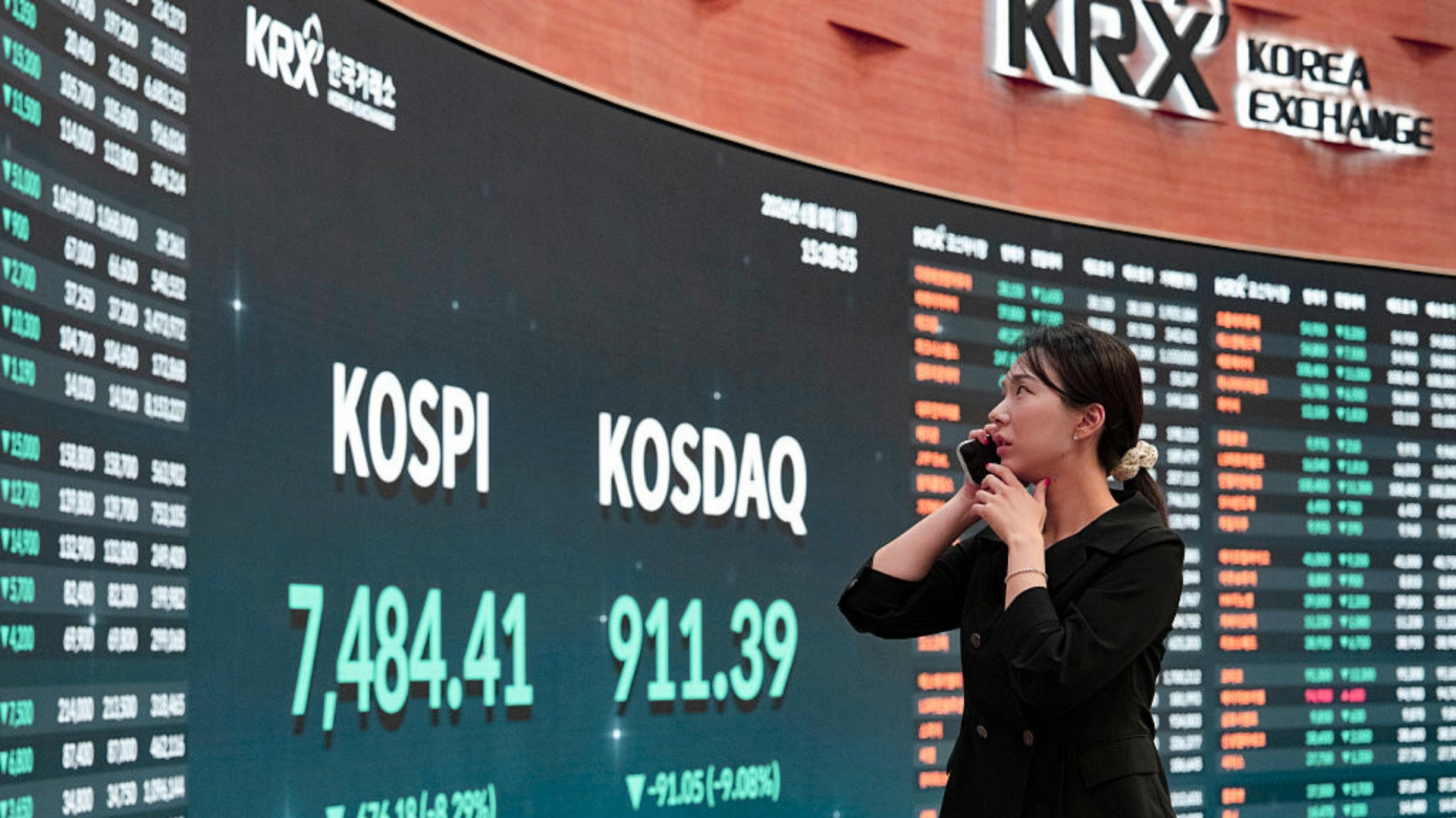 Woman looking at Korean stock market indices KOSPI and KOSDAQ