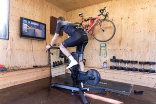 Image shows a rider cycling indoors