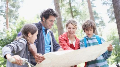 Family with bikes looking at map in woods