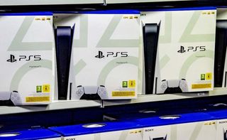PS5-konsoller står på rekke og rad på en butikkhylle.
