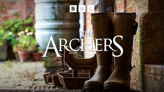 Promotional title card for The Archers featuring the title displayed over a pair of wellington boots in a rural English setting
