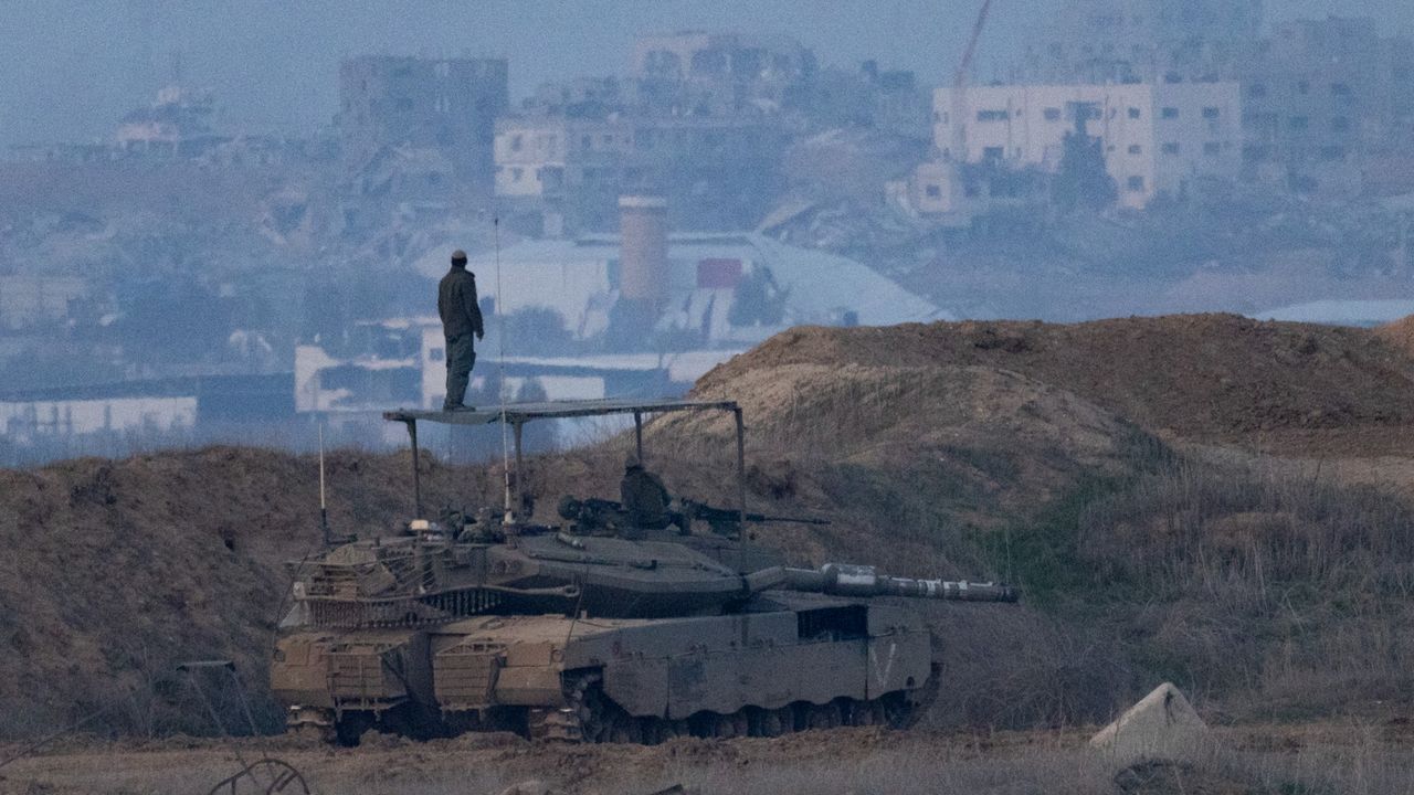 An Israeli soldier stands atop a tank after a ceasefire was announced between Israel and Hamas.