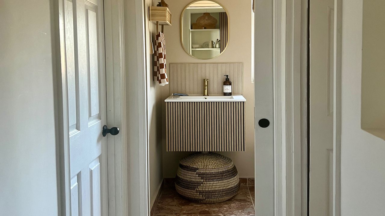 small bathroom with terrazzo tiles, sliding door and wall-hung vanity unit