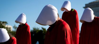 Demonstrators from the Center for Popular Democracy Action stand on the U.S. Supreme Court steps dressed in Handmaids Tale costumes to voice opposition to Judge Amy Coney Barretts nomination