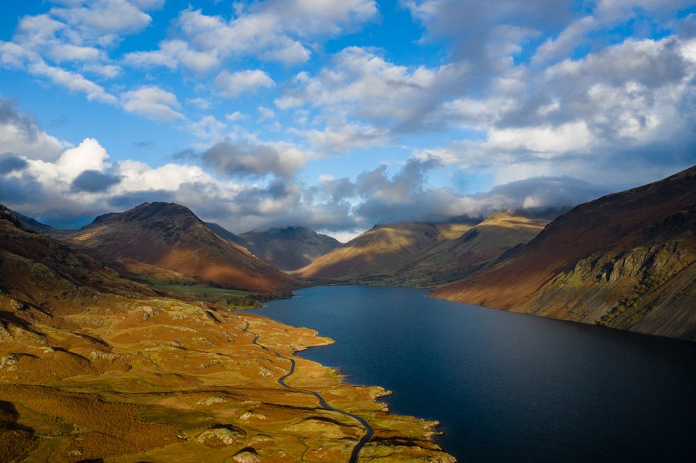 An aerial view of a lake running through a valley