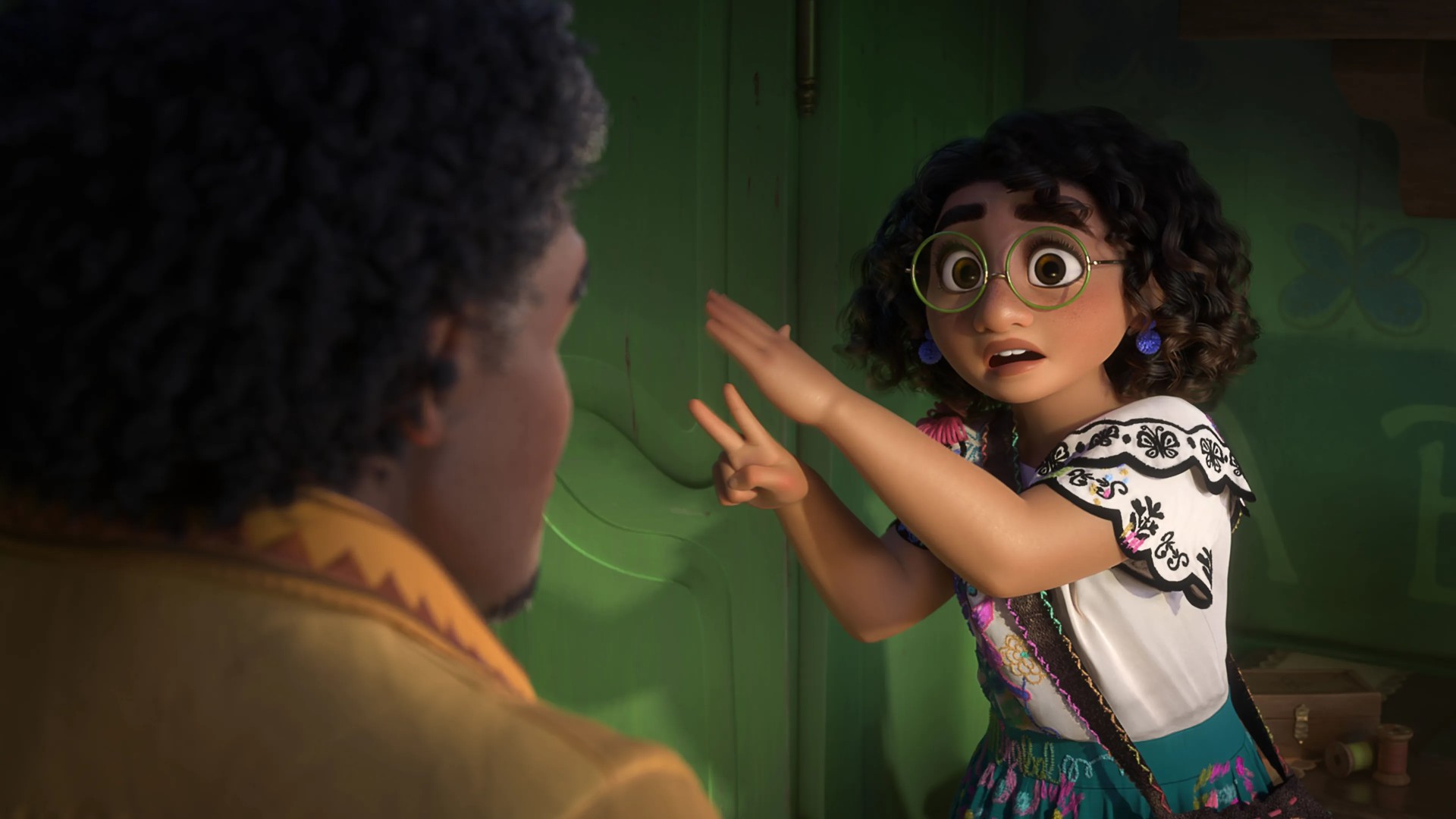Mirabel Madrigal from Encanto speaks urgently with wide eyes and animated hand gestures while facing her father, Agust&amp;iacute;n.