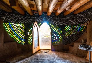 Earthship community in Taos showing colourful off grid homes nestled into the desert earth