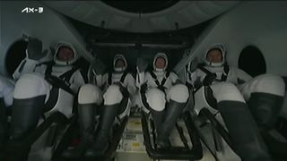 Four Ax-3 astronauts wave inside the SpaceX Dragon capsule Freedom after splashdown on Feb. 9, 2024.