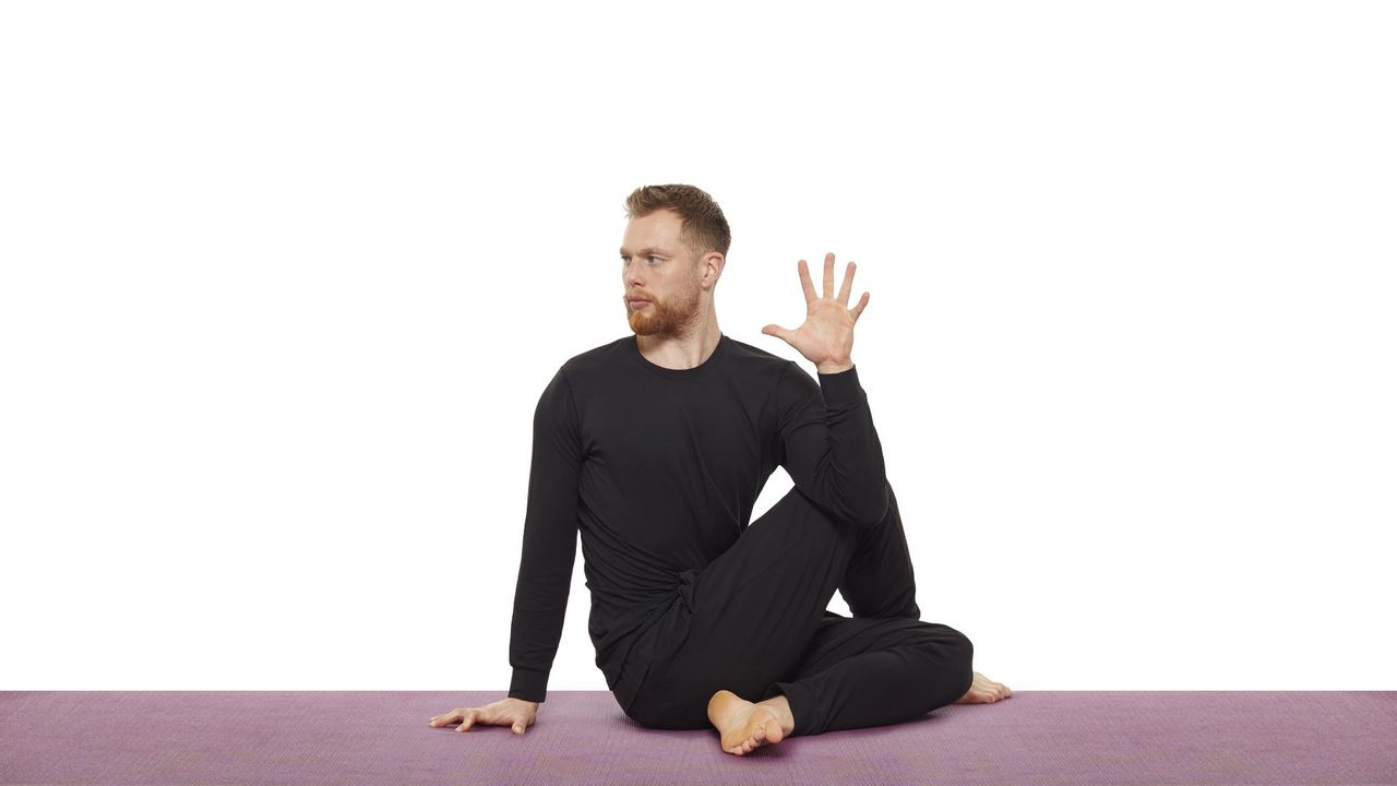 Yoga teacher Nick Higgins performs a seated twist