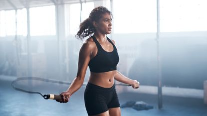 Cropped shot of an attractive and athletic young woman jumping rope in the gym