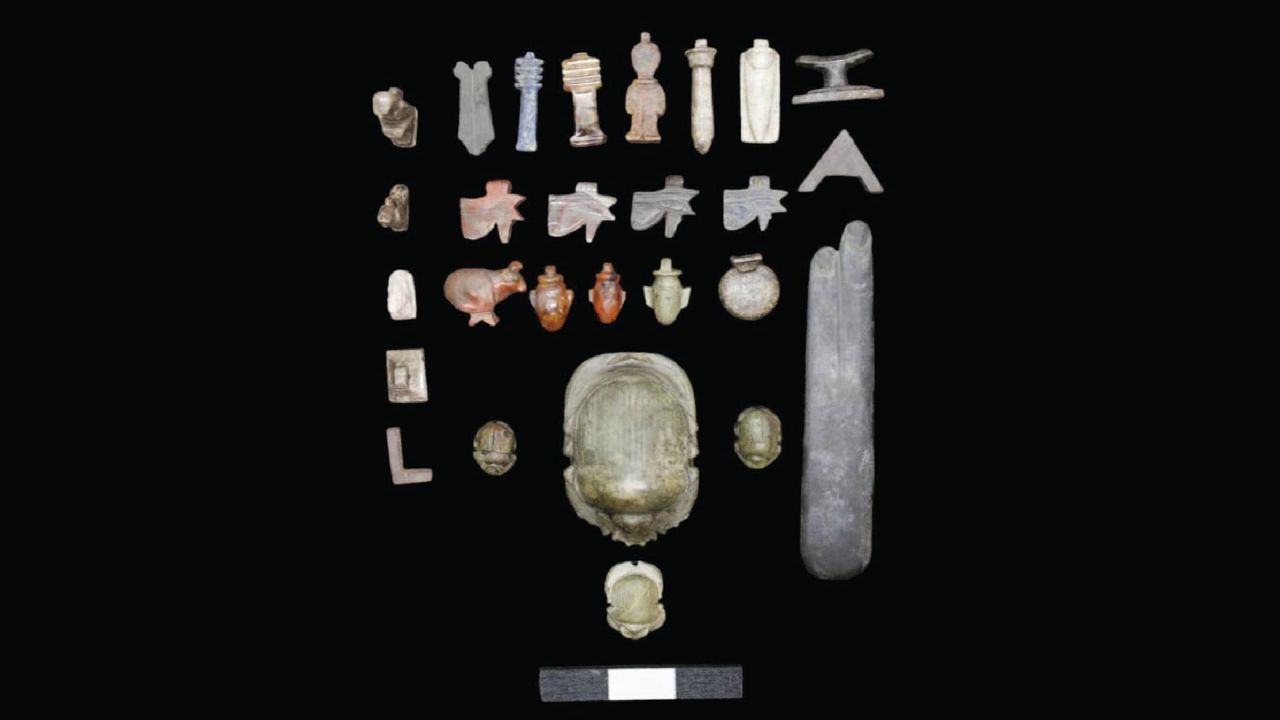 An array of stone artifacts depicting scarabs, cows, and abstract figures