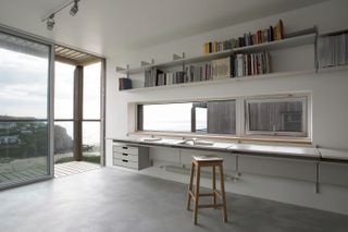 Book shelves above long desk
