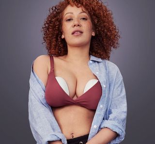 A woman wears the Elvie Pump double breast pump inside her bra