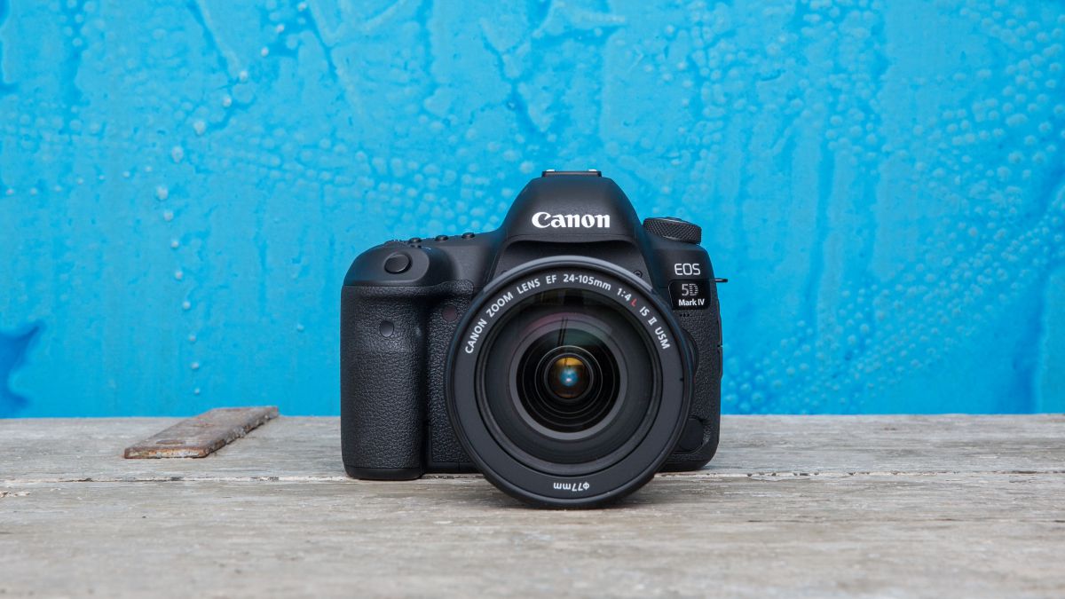 The Canon EOS 5D Mark IV, one of the best Canon cameras, sitting on a stone floor in front of a blue wall