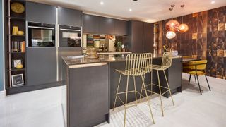 gold bar stools in large kitchen with metallic accents and dark cabinets