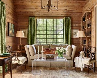 wood panelled cabin room with green curtains and french country decor