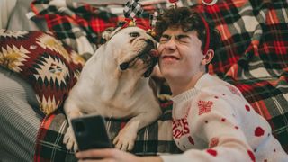 Dog and boy in Christmas jumper taking a selfie