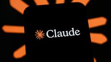 Anthropic Claude AI logo pictured on a smartphone screen, with AI tool branding blurred in background.
