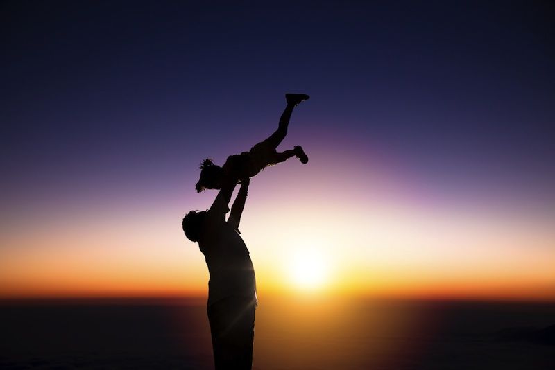 Father with daughter on the beach.