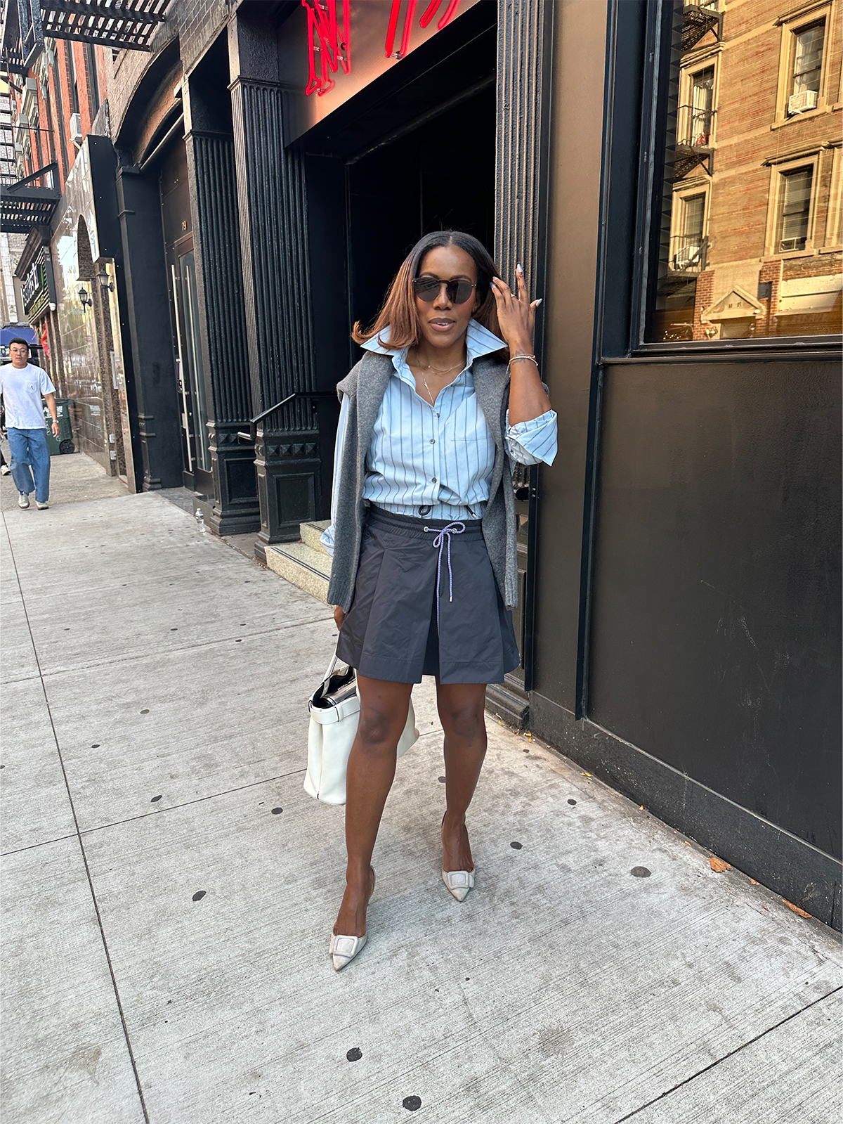 Tiffany Reid wearing a blue button-down shirt with a black skirt during fashion month.