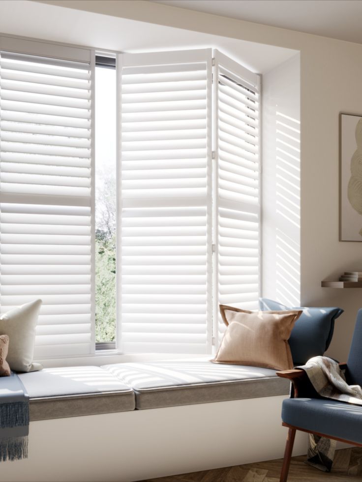 white plantation shutters and window seat with rust and blue cushions