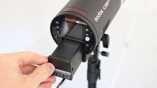 Battery being removed from a Godox Ad300Pro flash