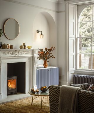 period property living room with wall lights in arched alcove and fireplace with log burner